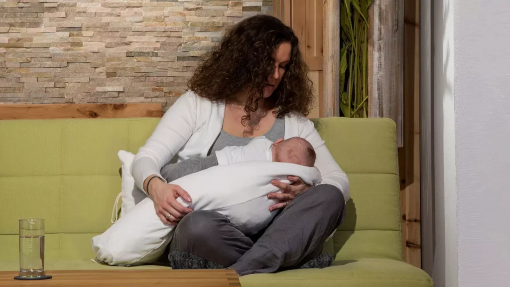 Frau stillt Baby mit Stillkissen von Allnatura
